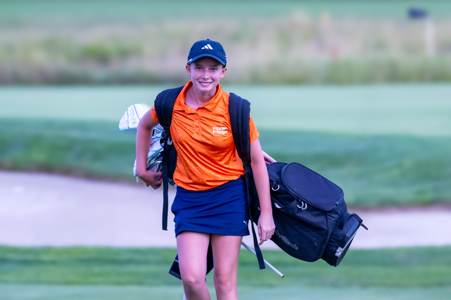 Olivia Huffman carrying her golf bag at a PGA Jr Tournament